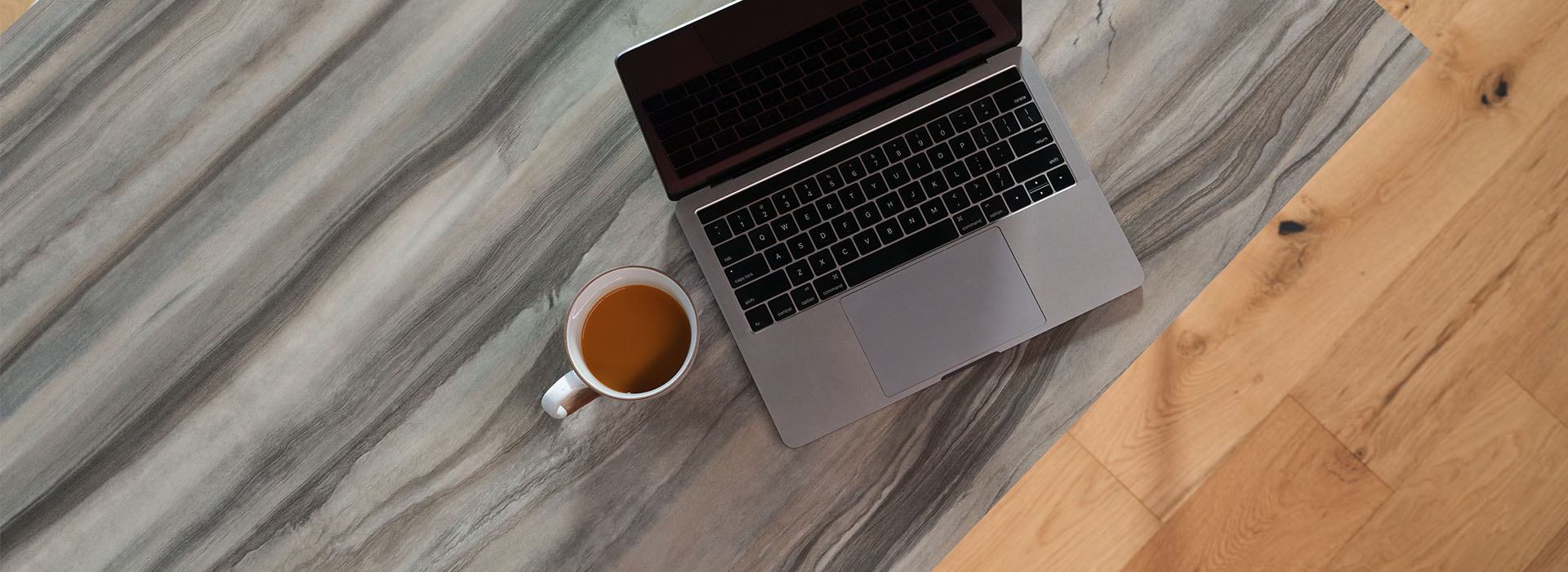 Acercamiento a la cubierta de Formica estilo mármol de un escritorio con laptop y café